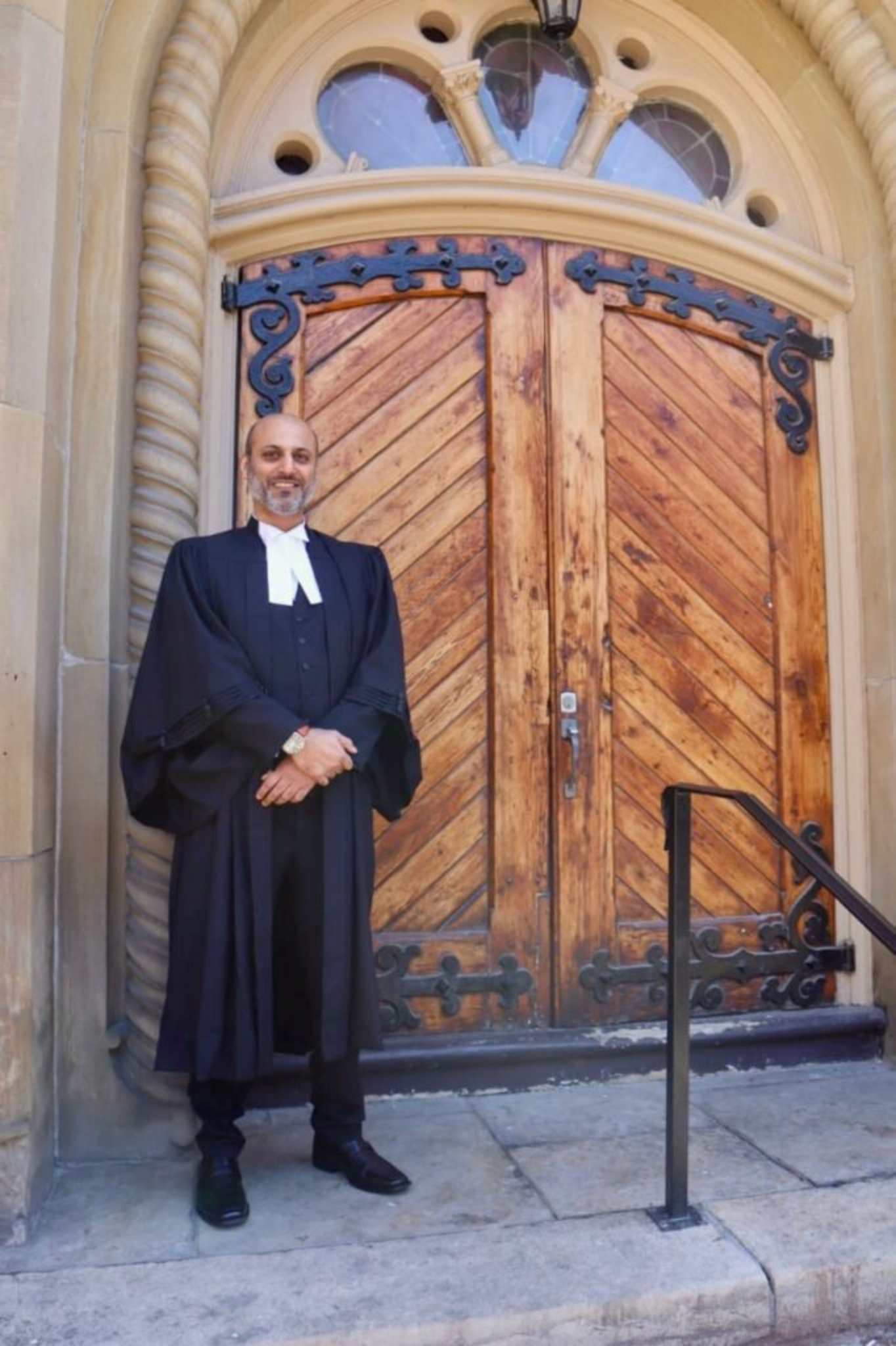 Home M. Hussain Chaudhry, criminal defense lawyer, standing outside the court in professional attire.
